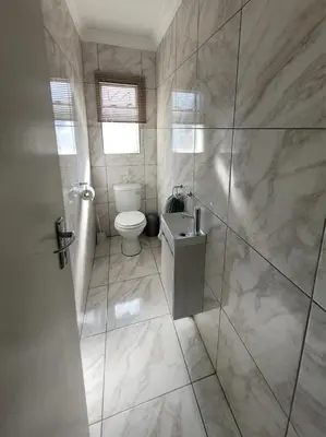 a bathroom with a toilet and a glass shower at 29B Zebra Street - InHimwe Guesthouse in Polokwane