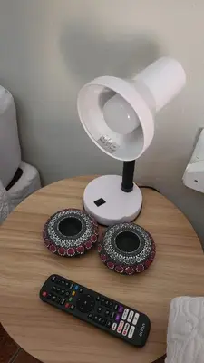 a table with a lamp and a remote control at 29B Zebra Street - InHimwe Guesthouse in Polokwane
