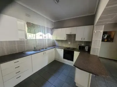 a kitchen with white cabinets and a counter top at 29B Zebra Street - InHimwe Guesthouse in Polokwane