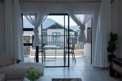 a living room with a view of a balcony at Fealathome Apartment in Midrand