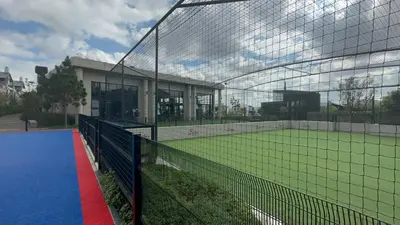 a tennis court with a net in front of a building at Fealathome Apartment in Midrand