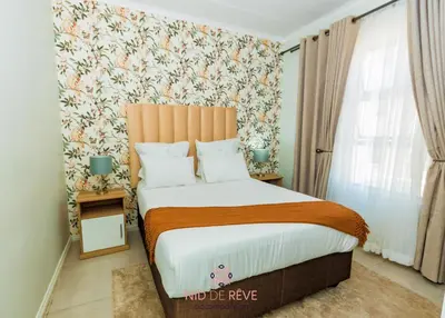 a bedroom with a large bed with a floral wallpaper at Nid de Rêve Accommodation in Midrand
