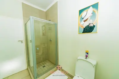 a bathroom with a glass shower and a toilet at Nid de Rêve Accommodation in Midrand