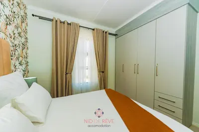 a bedroom with a white bed and a closet at Nid de Rêve Accommodation in Midrand