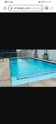 a large blue swimming pool in a building at Nid de Rêve Accommodation in Midrand