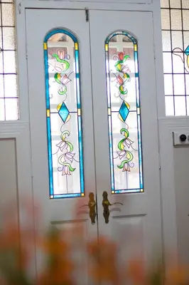 a pair of doors with stained glass windows at Oude Post Guesthouse and Cottage - The Old Postmaster's House in Lydenburg