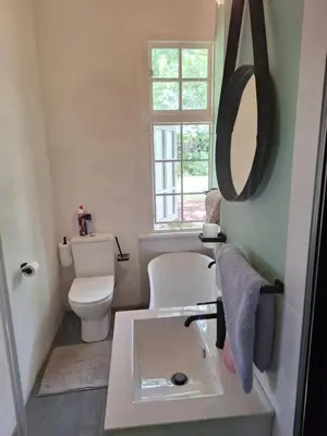 a bathroom with a sink and a toilet and a mirror at Oude Post Guesthouse and Cottage - The Old Postmaster's House in Lydenburg