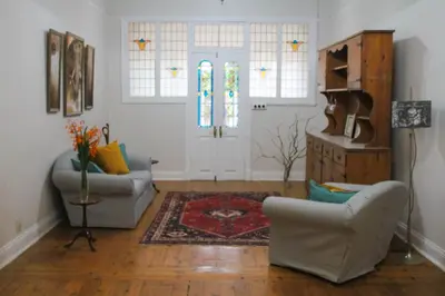 a living room with two chairs and a door with windows at Oude Post Guesthouse and Cottage - The Old Postmaster's House in Lydenburg