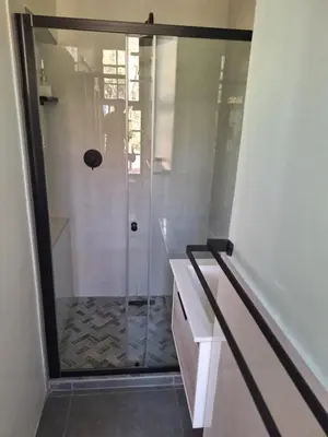 a shower with a glass door in a bathroom at Oude Post Guesthouse and Cottage - The Old Postmaster's House in Lydenburg