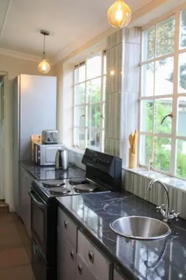 a kitchen with a stove and a sink at Oude Post Guesthouse and Cottage - The Old Postmaster's House in Lydenburg