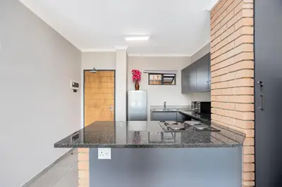 a kitchen with a counter top and a refrigerator at Opposite Mall of Africa Inn in Midrand