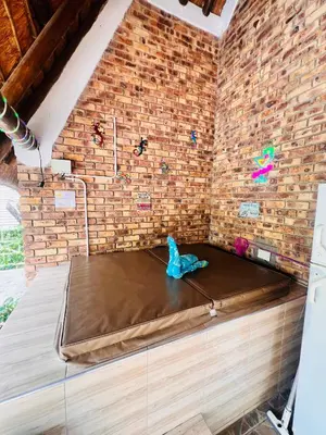 a bed in a room with a brick wall at Bliss in Marloth Park