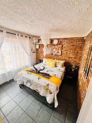 a bedroom with a large bed in a brick wall at Bliss in Marloth Park