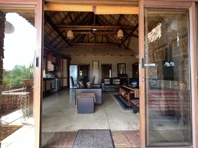 an open glass door of a living room at Pumula Bush Chalet in Mabula