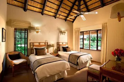 a bedroom with two beds in a room with windows at Kruger Park Lodge unit 34 in Hazyview