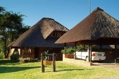 a white car parked in front of a hut at Kruger Park Lodge unit 34 in Hazyview