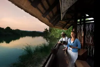 a man and a woman standing next to a river at Kruger Park Lodge unit 34 in Hazyview