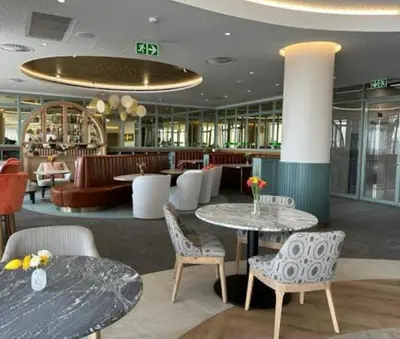 a hotel lobby with tables and chairs and a bar at Ellipse Waterfall Luxury Apartments in Midrand