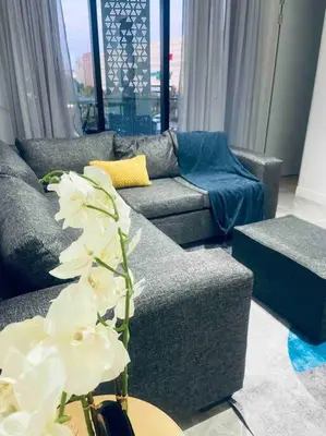 a living room with two couches and a table with flowers at Ellipse Waterfall Luxury Apartments in Midrand