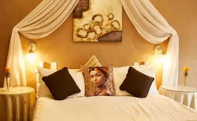a white bed with a picture of a woman on it at Villa Ticino Guest House in Sabie