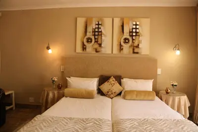 a bedroom with two beds and two tables at Villa Ticino Guest House in Sabie
