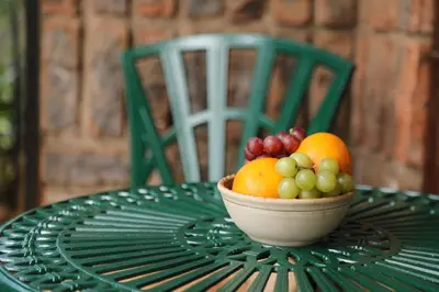 a bowl of fruit sitting on a green table at Villa Ticino Guest House in Sabie