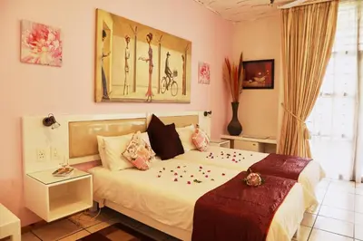 a bedroom with a bed with flowers on it at Villa Ticino Guest House in Sabie