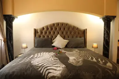 a bed with two zebras on it with flowers on it at Villa Ticino Guest House in Sabie