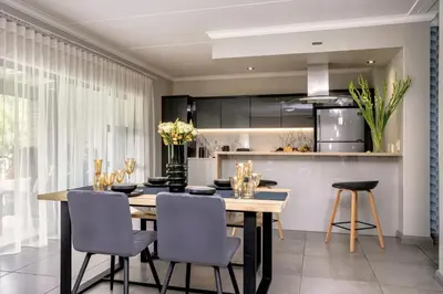 a kitchen and dining room with a table and chairs at Fore's Luxurious Home in Midrand