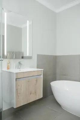 a bathroom with a white tub and a sink at Fore's Luxurious Home in Midrand