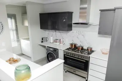 a kitchen with a stove and a microwave at Fore's Luxurious Home in Midrand