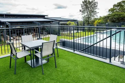 a balcony with a table and chairs on the grass at Fore's Luxurious Home in Midrand