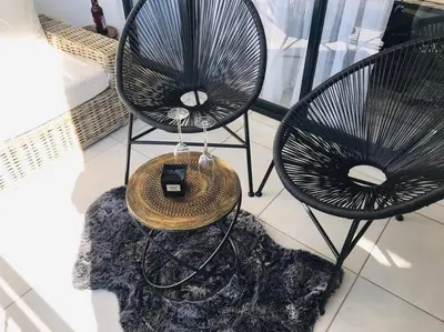 two black chairs and a table on a floor at Luxury beach lagoon 1 Bedroom apartment in Pretoria