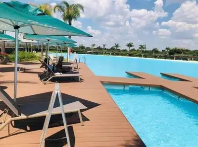 a swimming pool with lounge chairs and umbrellas at Luxury beach lagoon 1 Bedroom apartment in Pretoria
