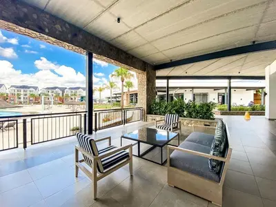 a living room with a table and chairs on a balcony at Luxury beach lagoon 1 Bedroom apartment in Pretoria