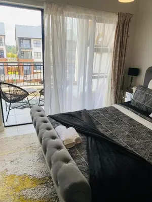 a bedroom with a large bed with a large window at Luxury beach lagoon 1 Bedroom apartment in Pretoria