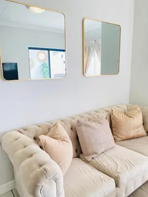 a white couch in a living room with two mirrors at Luxury beach lagoon 1 Bedroom apartment in Pretoria