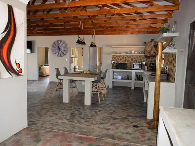 a kitchen and dining room with a table and chairs at Klipdrift Sands Game Lodge in Dinokeng Game Reserve