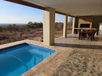 a house with a swimming pool and a piano at Klipdrift Sands Game Lodge in Dinokeng Game Reserve