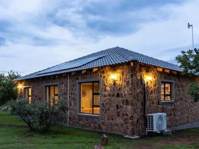 a small stone house with lights on it at Klipdrift Sands Game Lodge in Dinokeng Game Reserve