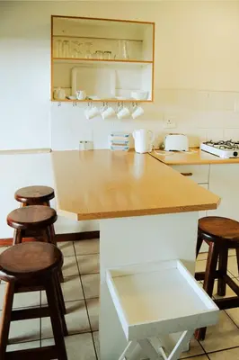 a kitchen with a counter and stools in it at Machado Stay Pecan Cottage 1 in Machadodorp
