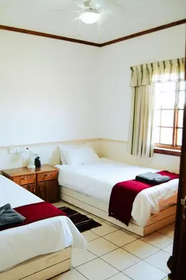 a bedroom with two beds and a window at Machado Stay Pecan Cottage 1 in Machadodorp