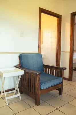 a blue chair sitting in a room with a table at Machado Stay Pecan Cottage 1 in Machadodorp