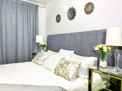 a bed with white sheets and pillows in a bedroom at Siena Sun Luxury Suites 2 in Midrand