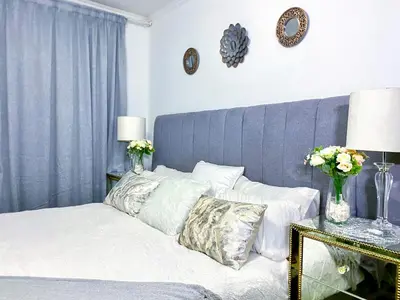 a bedroom with a bed with a blue headboard and pillows at Siena Sun Luxury Suites 2 in Midrand