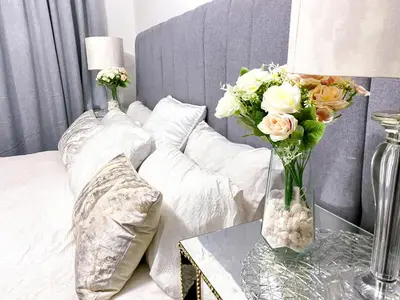 a bedroom with a bed with a vase of flowers on a table at Siena Sun Luxury Suites 2 in Midrand