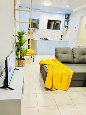 a living room with a couch and a tv at Modern studio apartments in Secunda