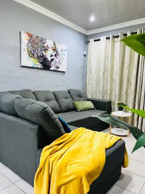 a living room with a couch and a yellow blanket at Modern studio apartments in Secunda