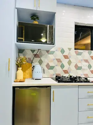 a kitchen with a microwave and a stove top oven at Modern studio apartments in Secunda