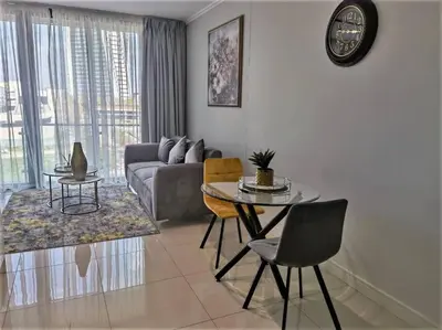 a living room with a couch and a table at Executive Suite at Ellipse Waterfall Midrand in Midrand